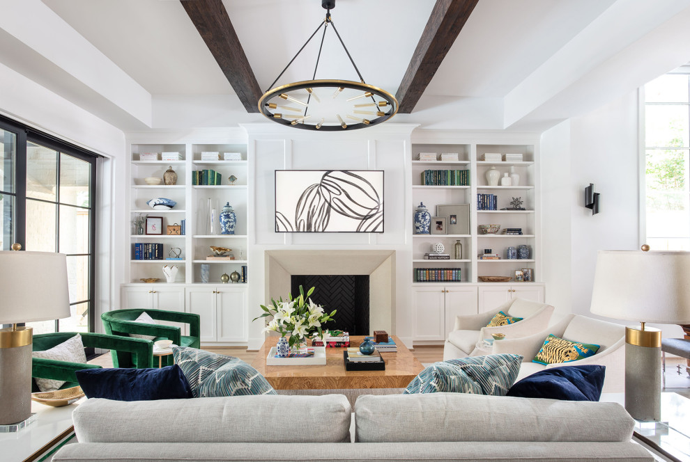 Inspiration for an expansive contemporary open concept family room in Houston with white walls, light hardwood floors, a standard fireplace, a stone fireplace surround, a wall-mounted tv, exposed beam and panelled walls.