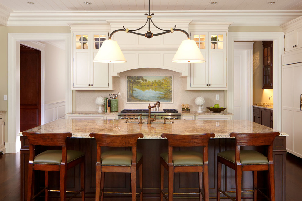 Photo of a traditional l-shaped kitchen in New York with an undermount sink, shaker cabinets, white cabinets, beige splashback, panelled appliances, marble benchtops, dark hardwood floors and with island.