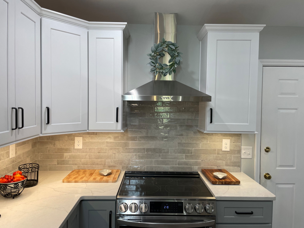 Mid-sized transitional u-shaped vinyl floor and brown floor eat-in kitchen photo with shaker cabinets, white cabinets, quartz countertops, gray backsplash, subway tile backsplash, stainless steel appliances, no island and white countertops
