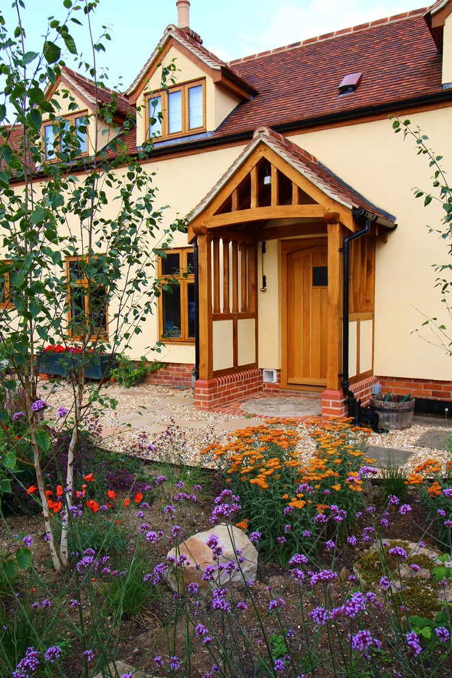 Photo of a mid-sized country front door in Surrey with a single front door and a medium wood front door.