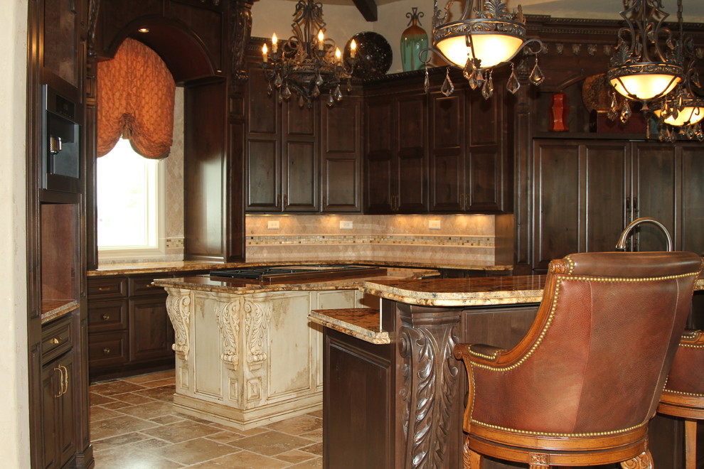 Inspiration for a large traditional l-shaped eat-in kitchen in Austin with raised-panel cabinets, dark wood cabinets, granite benchtops, beige splashback, ceramic splashback, panelled appliances, travertine floors, multiple islands, beige floor, a farmhouse sink and brown benchtop.
