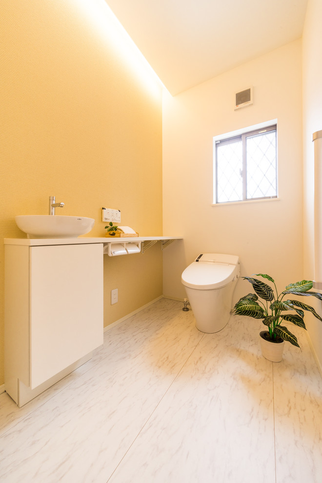 Photo of a large scandinavian powder room in Other with yellow walls, a vessel sink and beige floor.