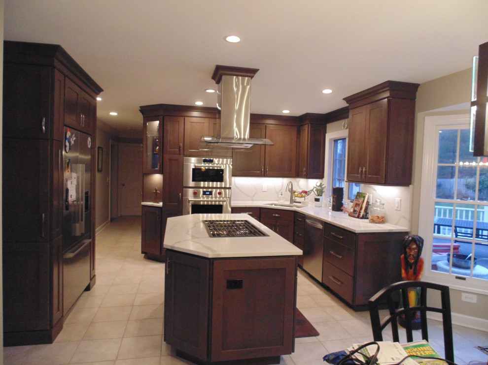 Eat-in kitchen - mid-sized transitional u-shaped ceramic tile and beige floor eat-in kitchen idea with an undermount sink, recessed-panel cabinets, dark wood cabinets, quartz countertops, white backsplash, stone slab backsplash, stainless steel appliances, an island and white countertops