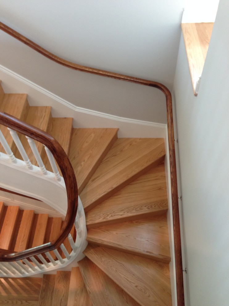 This is an example of an expansive traditional wood u-shaped staircase in DC Metro with wood risers and wood railing.