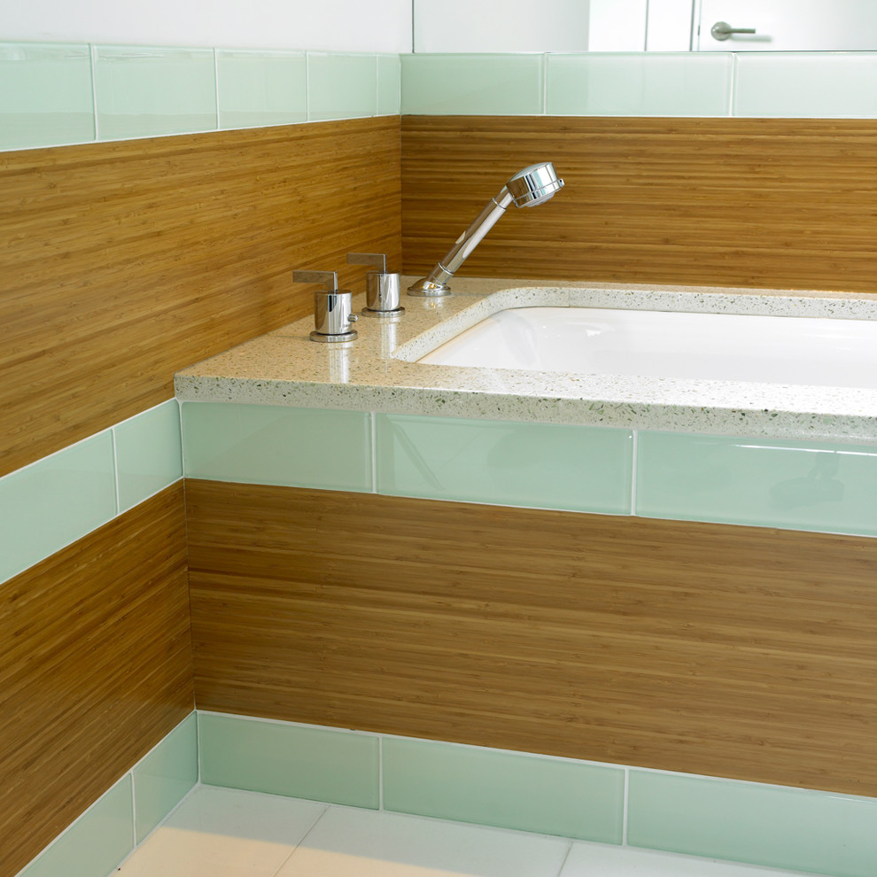This is an example of a contemporary bathroom in Vancouver with an undermount tub, green tile and subway tile.