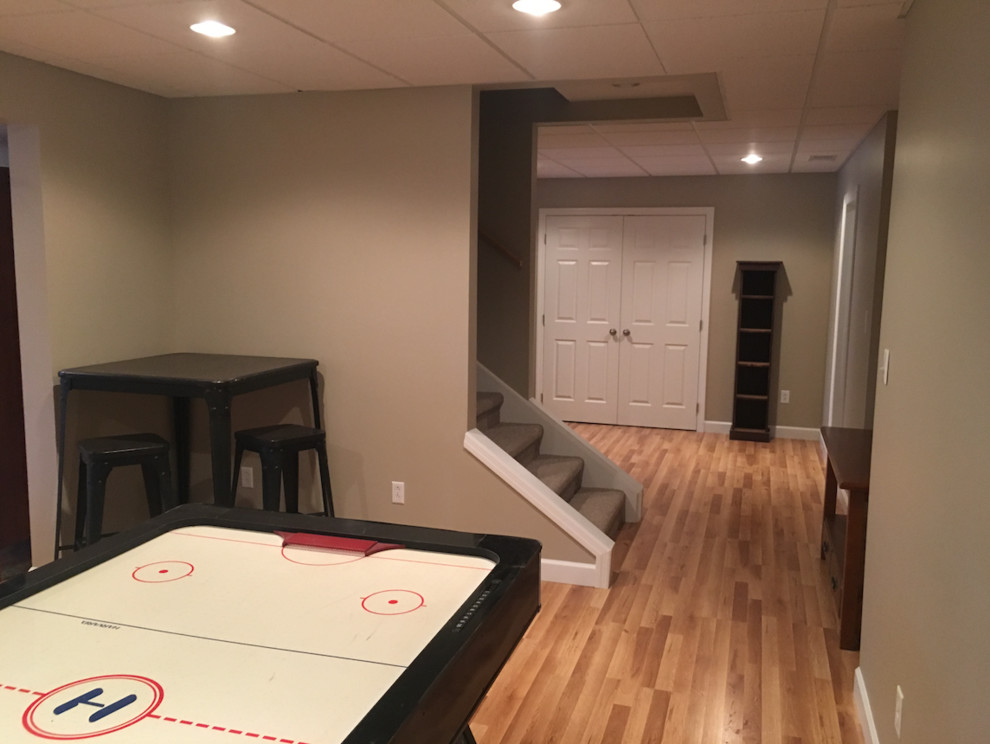 Inspiration for a large contemporary underground medium tone wood floor and brown floor basement remodel with beige walls and no fireplace