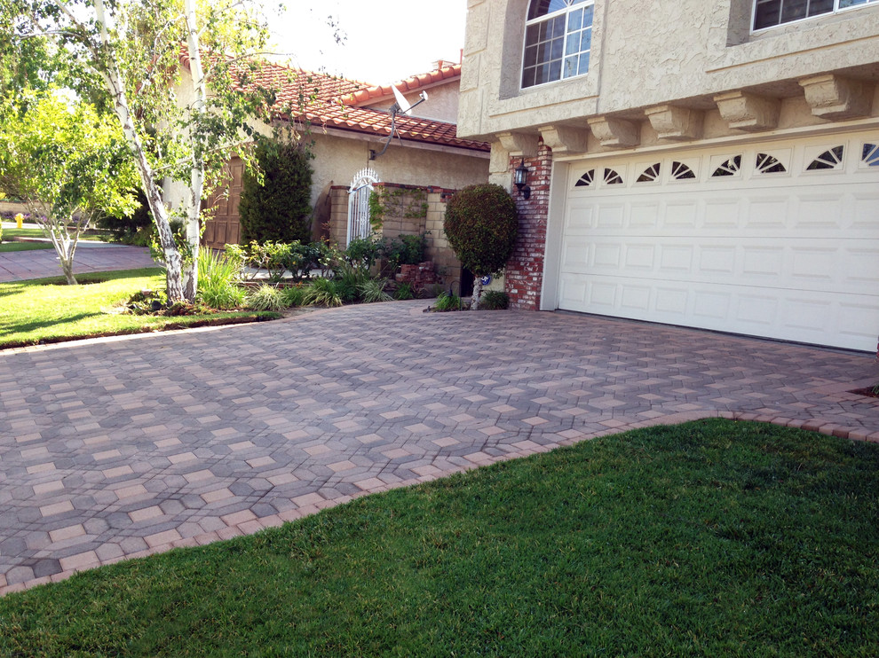 Mid-sized traditional front yard partial sun driveway in Los Angeles with concrete pavers.