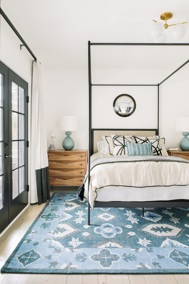 Transitional bedroom in Charleston with white walls and light hardwood floors.