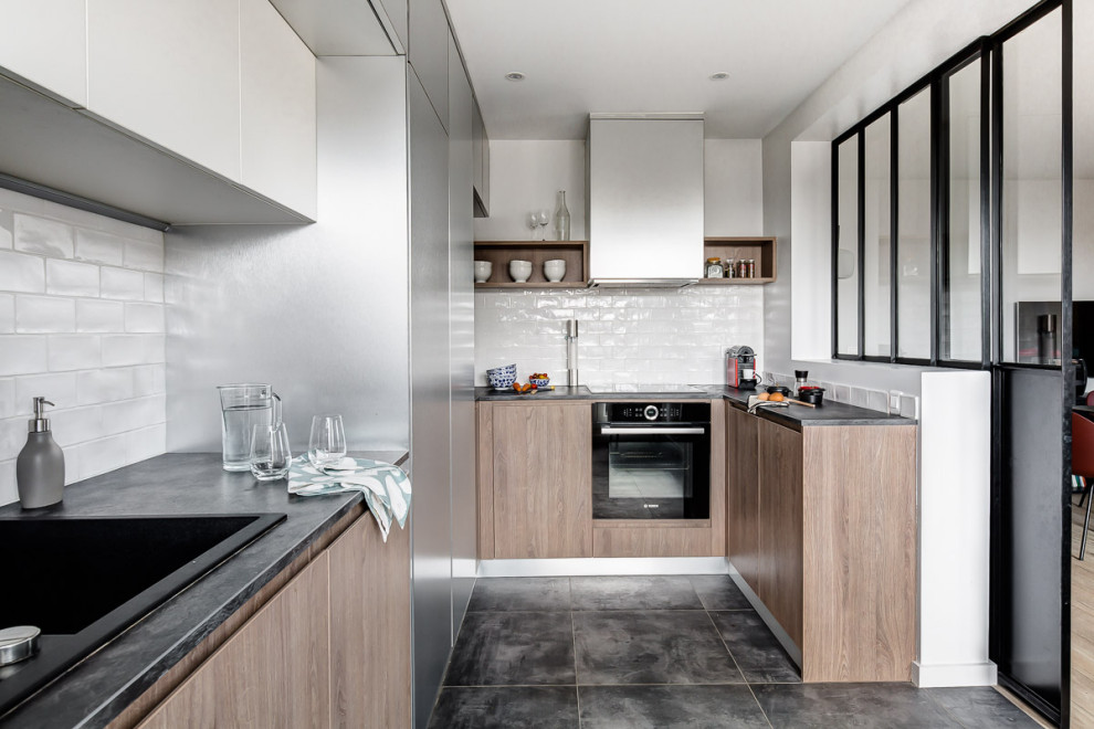 Aménagement de cuisine ouverte in U With un évier 1 bac, une crédence blanche, une crédence en carreau de porcelaine, un électroménager noir, un sol en carrelage de céramique, aucun îlot and un sol gris.