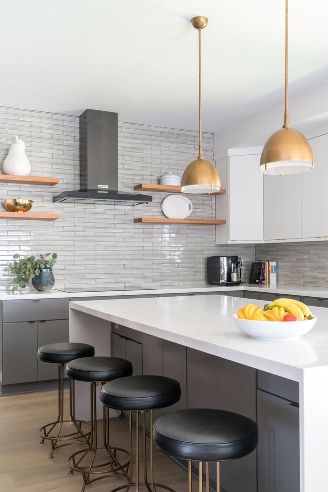 Mid-sized transitional galley medium tone wood floor enclosed kitchen photo with an undermount sink, flat-panel cabinets, gray cabinets, quartz countertops, stainless steel appliances, an island and white countertops
