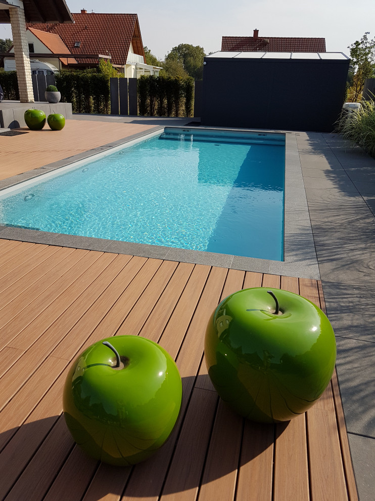 Großer Mediterraner Pool neben dem Haus in rechteckiger Form mit Natursteinplatten in Frankfurt am Main