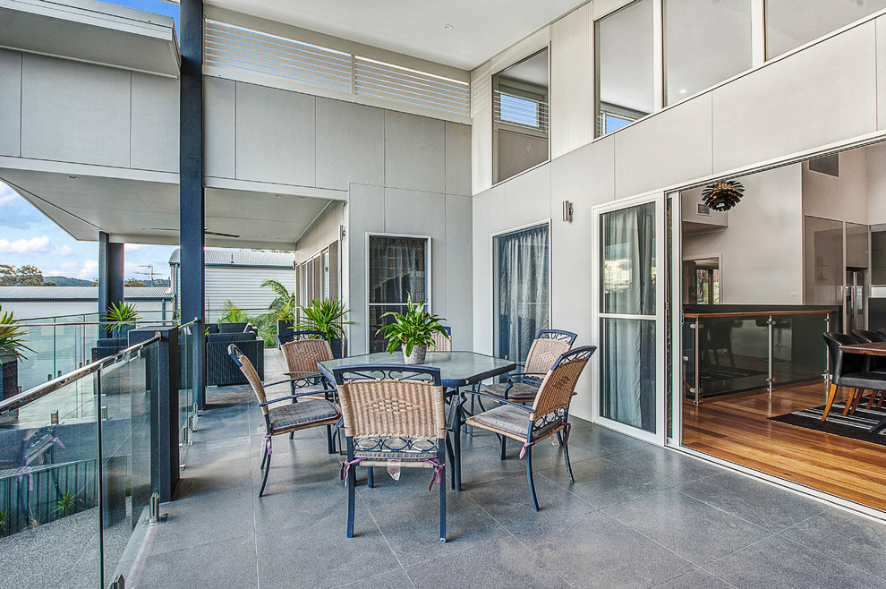 Photo of a contemporary patio in Newcastle - Maitland with tile and a roof extension.
