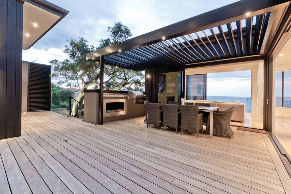 Design ideas for a large contemporary side yard deck in Auckland with an outdoor kitchen and a pergola.