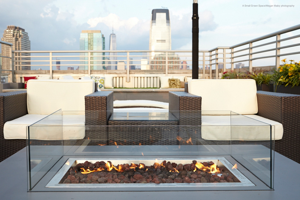 This is an example of a large contemporary rooftop deck in New York with a fire feature and no cover.