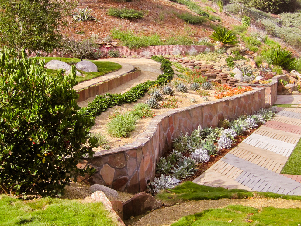 Photo of a backyard partial sun xeriscape in San Diego with a retaining wall.