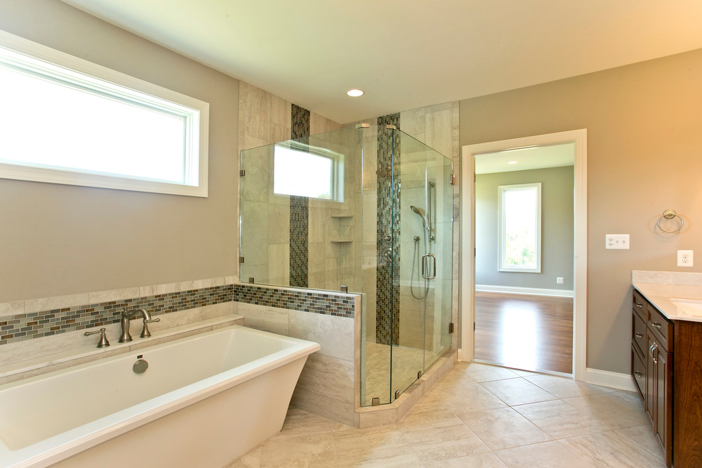 This is an example of a large traditional master bathroom in DC Metro with a freestanding tub, a double shower, beige tile, glass tile, beige walls and ceramic floors.