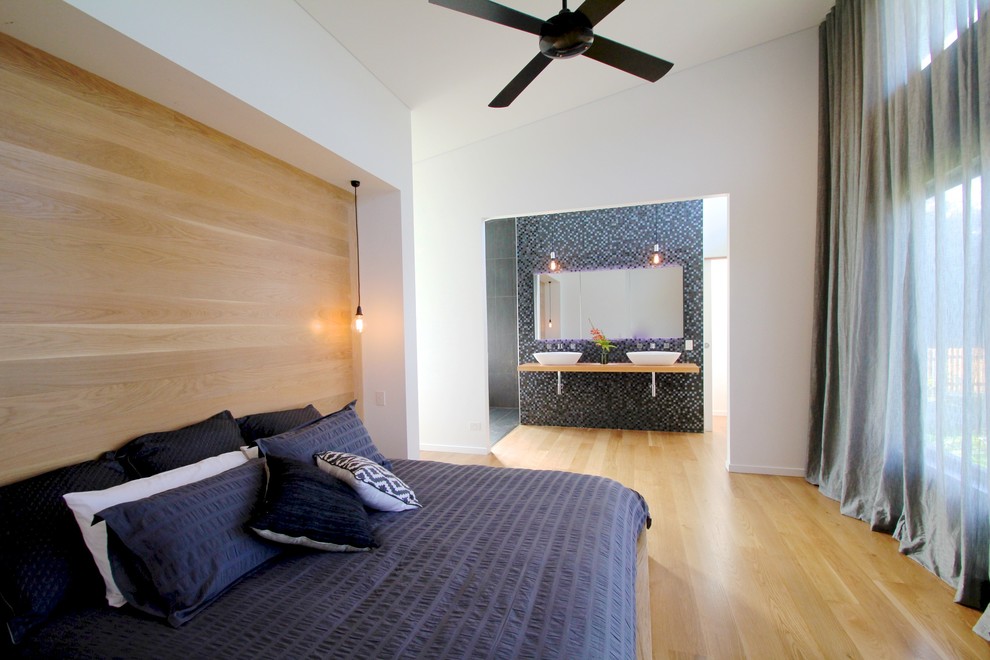 Inspiration for a large contemporary master bedroom in Sydney with white walls and light hardwood floors.