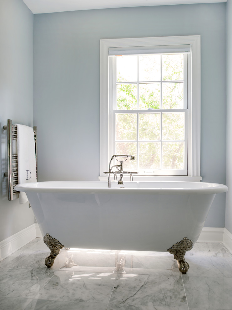 This is an example of a mid-sized traditional master bathroom in Chicago with an undermount sink, quartzite benchtops, a claw-foot tub, an alcove shower, a two-piece toilet, gray tile, stone tile, blue walls, marble floors, furniture-like cabinets, blue cabinets, white floor, a hinged shower door, white benchtops, a niche, a double vanity and a freestanding vanity.