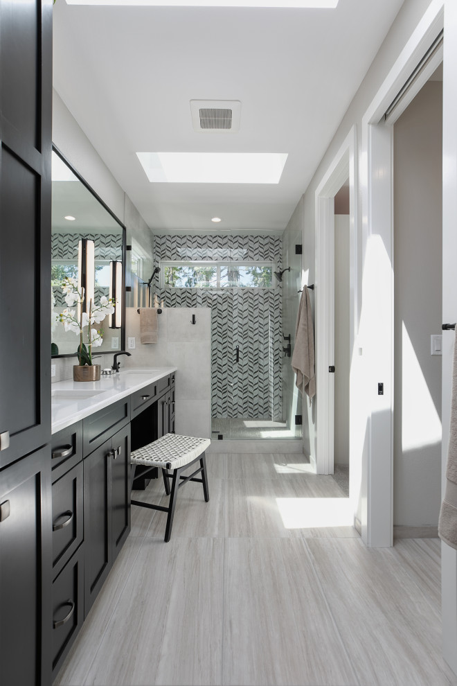 На фото: огромная главная ванная комната в стиле модернизм с фасадами в стиле шейкер, черными фасадами, душем в нише, унитазом-моноблоком, черно-белой плиткой, керамогранитной плиткой, белыми стенами, полом из керамогранита, накладной раковиной, столешницей из искусственного кварца, серым полом, душем с распашными дверями, белой столешницей, сиденьем для душа, тумбой под две раковины и встроенной тумбой с