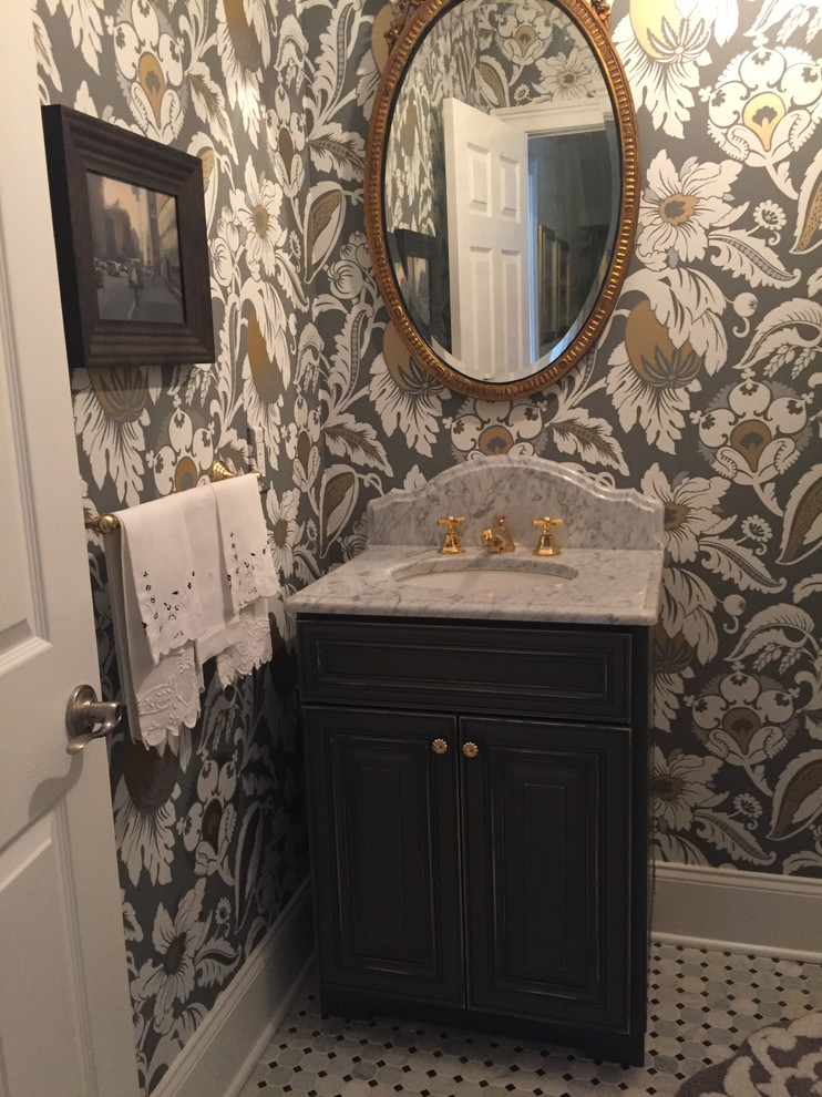 Photo of a small traditional powder room in Philadelphia with raised-panel cabinets, distressed cabinets, a two-piece toilet, stone tile, multi-coloured walls, marble floors, an undermount sink, marble benchtops and gray tile.