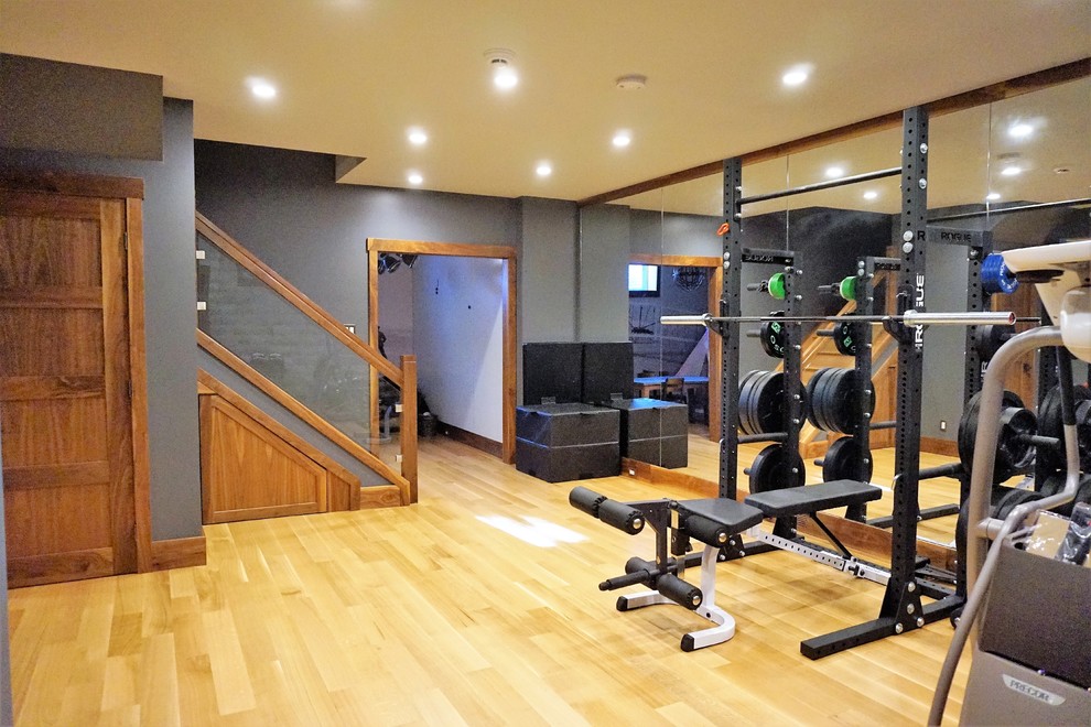 Photo of a mid-sized country home weight room in Calgary with grey walls, light hardwood floors and beige floor.