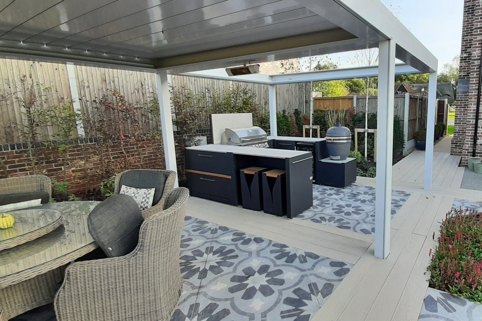 Idée de décoration pour une terrasse arrière design de taille moyenne avec une cuisine d'été, du carrelage et une pergola.