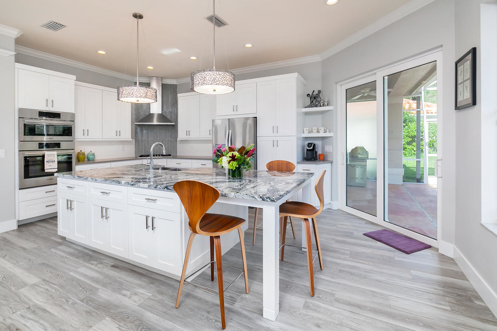Inspiration for a mid-sized transitional l-shaped open plan kitchen in Tampa with a farmhouse sink, shaker cabinets, white cabinets, porcelain floors, with island and grey floor.