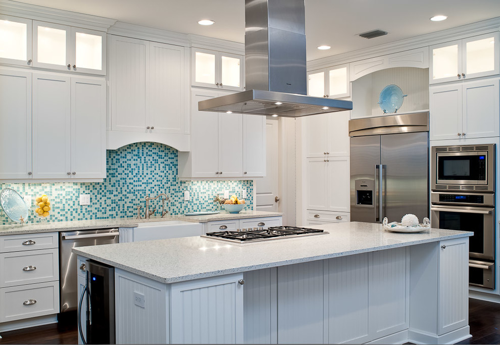 Design ideas for a tropical kitchen in Miami with a farmhouse sink, shaker cabinets, white cabinets, blue splashback, mosaic tile splashback and stainless steel appliances.