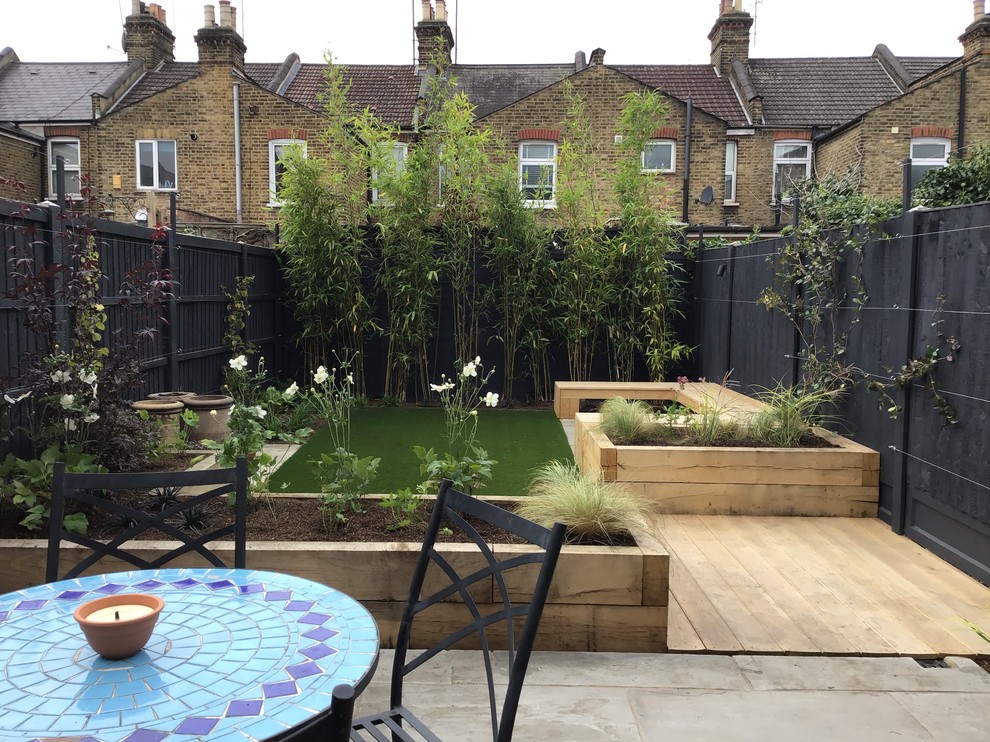Inspiration for a mid-sized contemporary backyard partial sun garden for summer in London with with raised garden bed and natural stone pavers.