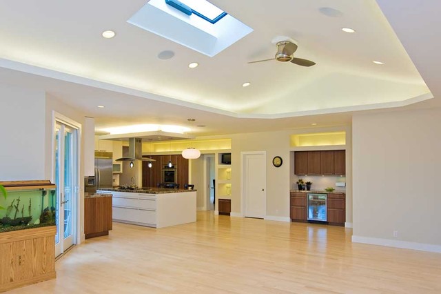 Family room w/ vaulted ceiling skylight opens to kitchen  