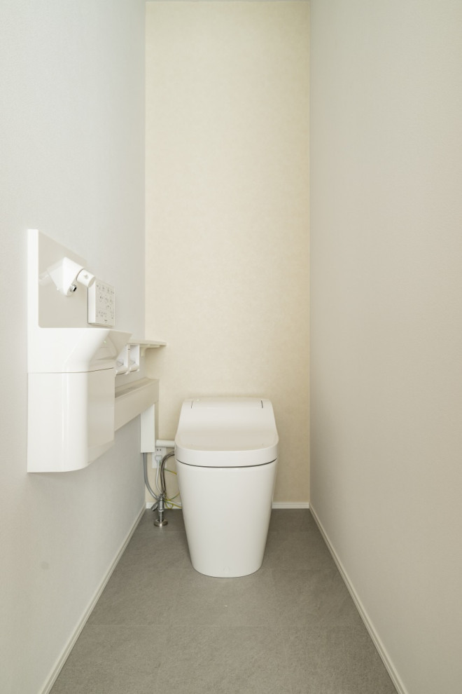 Aménagement d'un WC et toilettes moderne de taille moyenne avec un bidet, un mur blanc, un sol en vinyl, un sol gris, un plafond en papier peint et du papier peint.