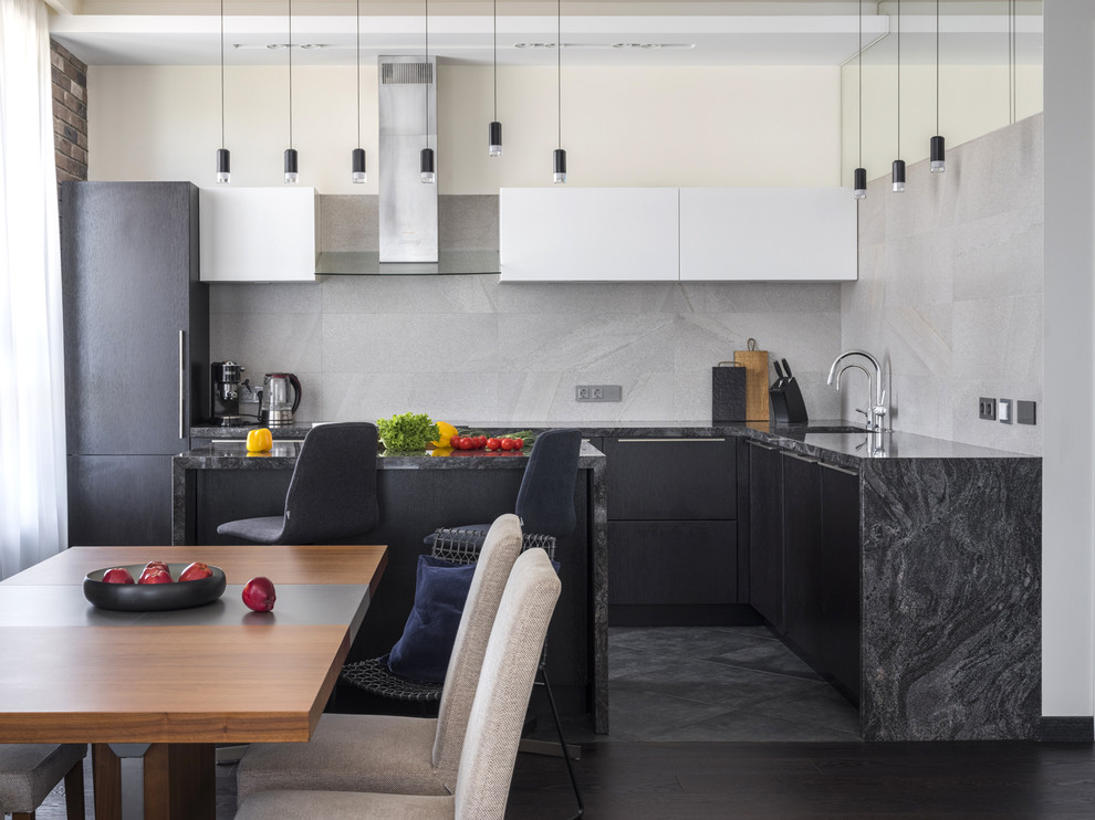 Inspiration for a mid-sized contemporary open plan kitchen in Moscow with an undermount sink, granite benchtops, grey splashback, porcelain splashback, porcelain floors, with island, grey floor, black cabinets and black benchtop.