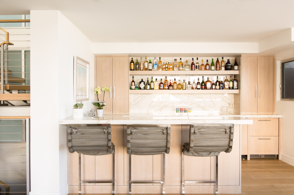 Inspiration for a contemporary seated home bar in Austin with flat-panel cabinets, medium wood cabinets, marble benchtops, multi-coloured splashback, marble splashback, medium hardwood floors, brown floor and multi-coloured benchtop.