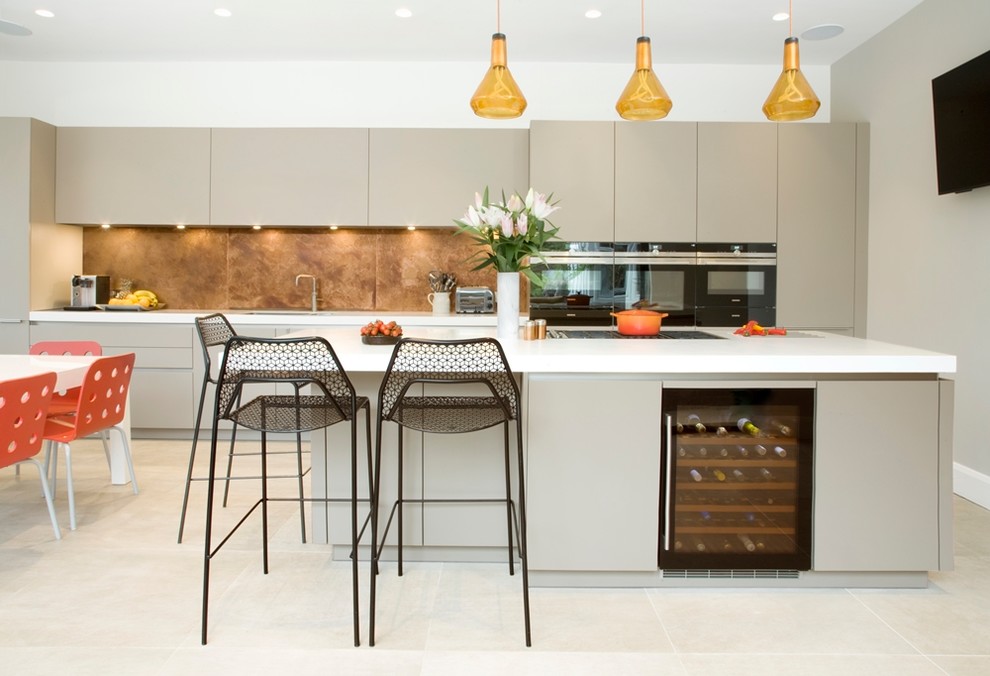 Inspiration for a large contemporary single-wall eat-in kitchen in Surrey with an undermount sink, flat-panel cabinets, grey cabinets, solid surface benchtops, metallic splashback, metal splashback, black appliances, cement tiles, with island and grey floor.