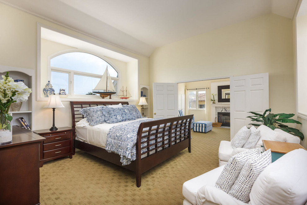 Inspiration for a beach style bedroom in San Diego with beige walls and carpet.