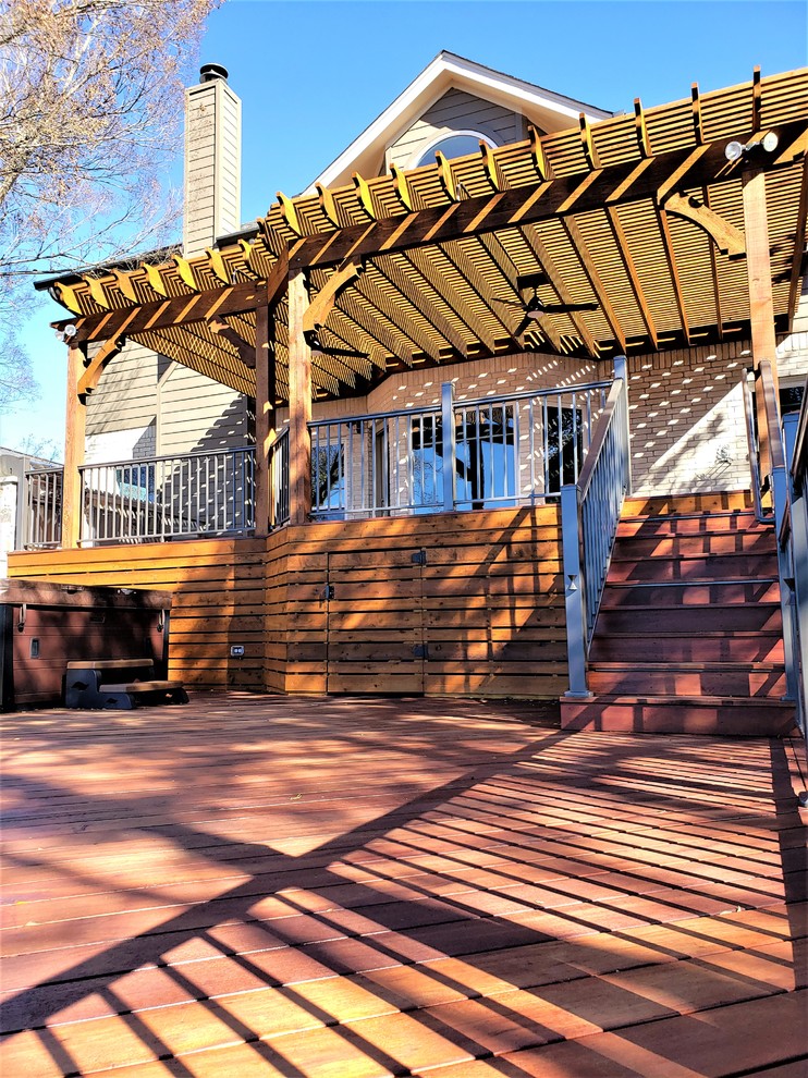 This is an example of an expansive eclectic backyard deck in Austin with an outdoor kitchen and a pergola.