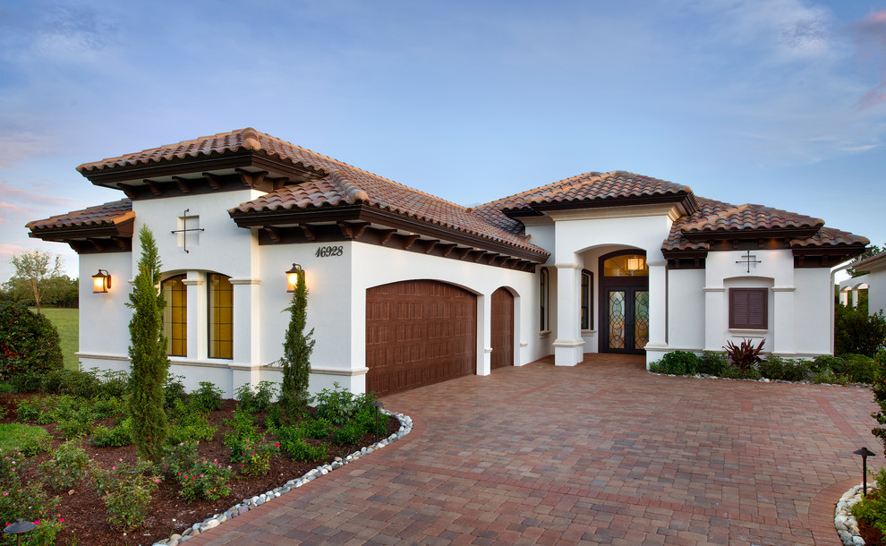 This is an example of a mediterranean one-storey white exterior in Miami with a hip roof.