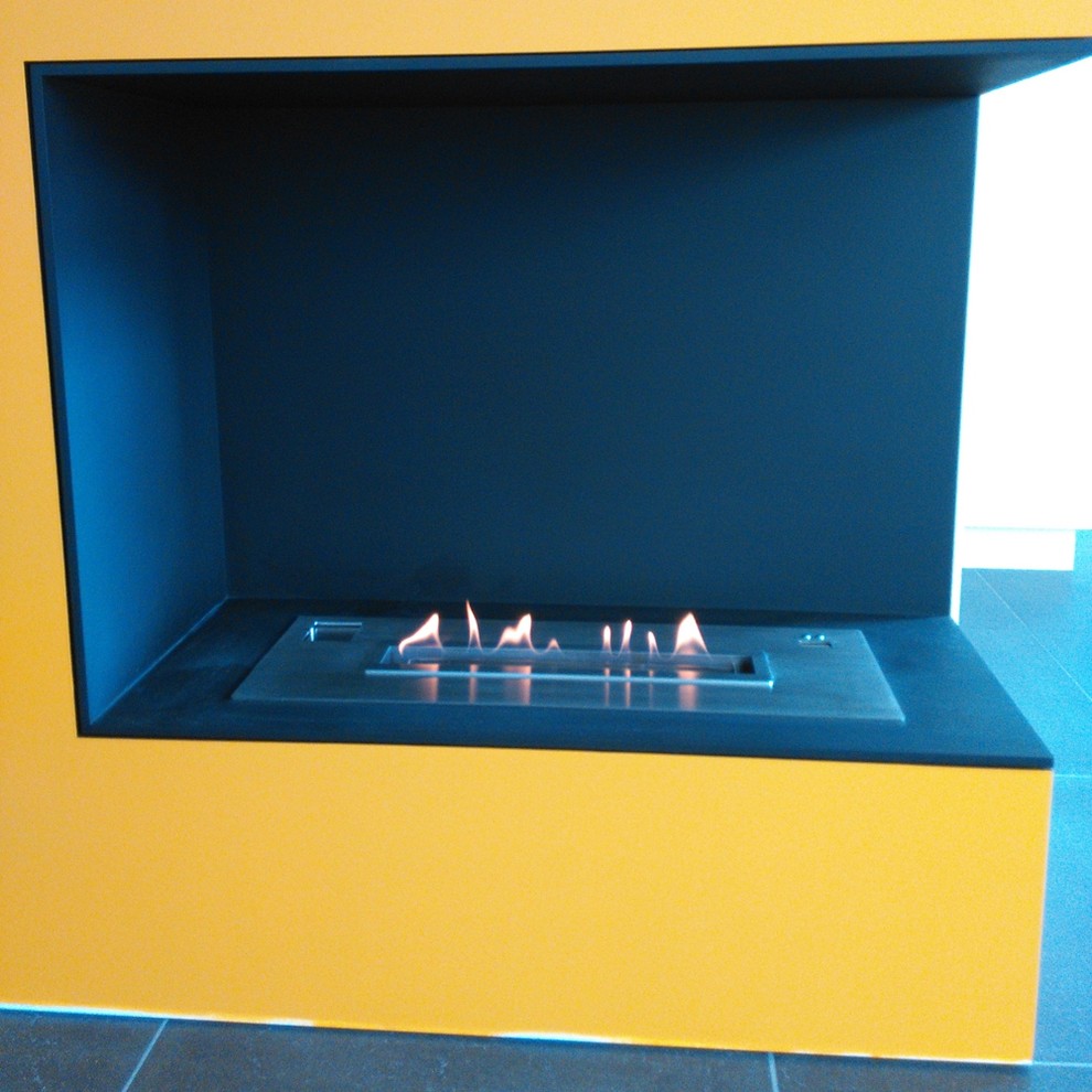 Inspiration for a large modern built-in desk limestone floor home design remodel with yellow walls, a standard fireplace and a stone fireplace