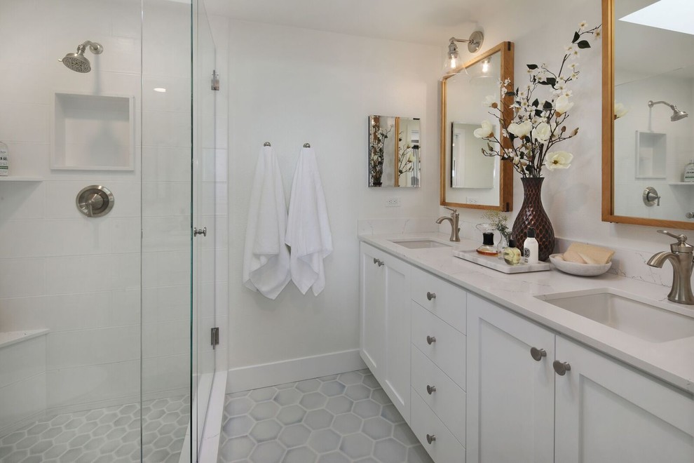 Mid-sized transitional master bathroom in Orange County with recessed-panel cabinets, white cabinets, an alcove shower, a two-piece toilet, white tile, ceramic tile, white walls, ceramic floors, an undermount sink, engineered quartz benchtops, grey floor, a hinged shower door and white benchtops.