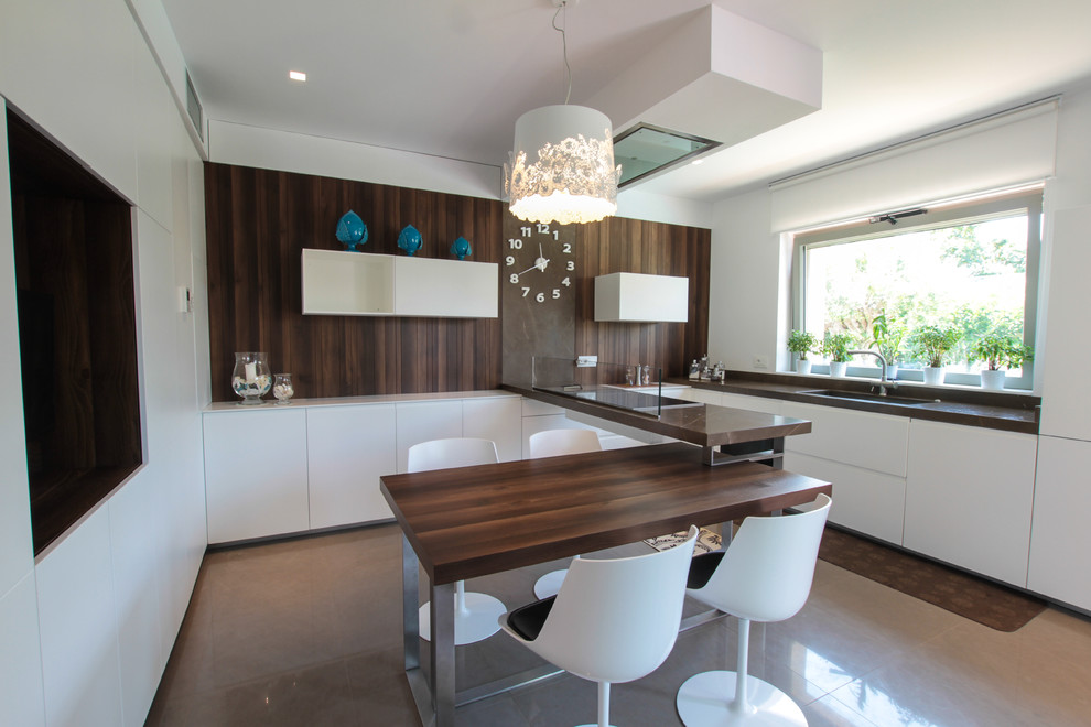 Inspiration for a large contemporary l-shaped eat-in kitchen in Bari with an undermount sink, flat-panel cabinets, white cabinets, brown splashback, panelled appliances, a peninsula and glass sheet splashback.
