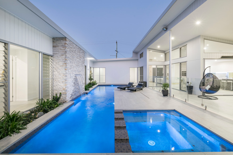 Photo of a contemporary courtyard rectangular lap pool in Brisbane with a hot tub.