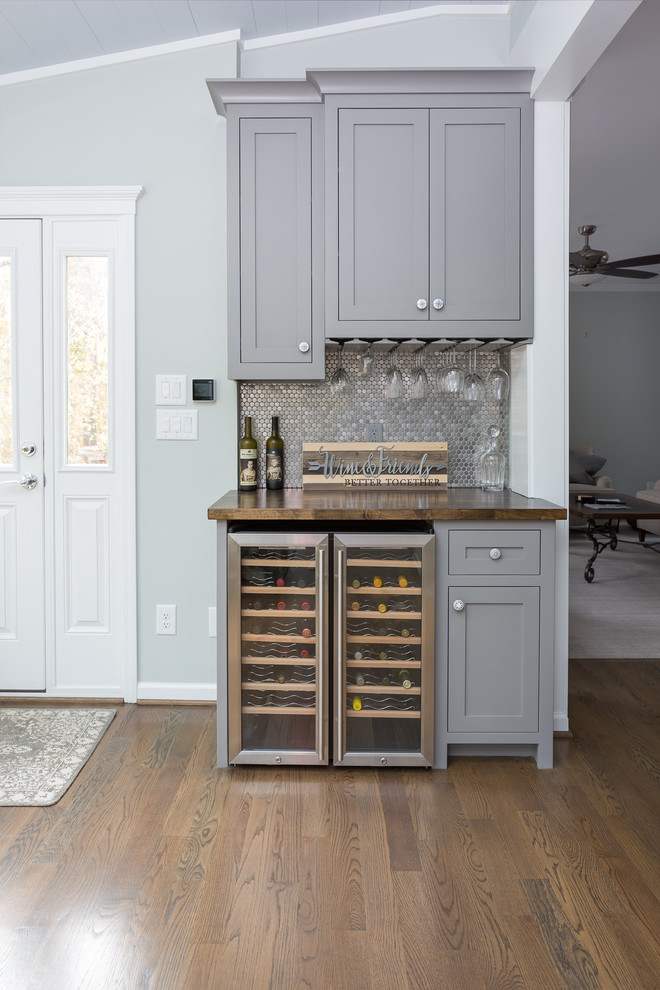 Mid-sized transitional single-wall wet bar in Raleigh with shaker cabinets, wood benchtops, no sink, grey cabinets, grey splashback, mosaic tile splashback, dark hardwood floors, brown floor and brown benchtop.