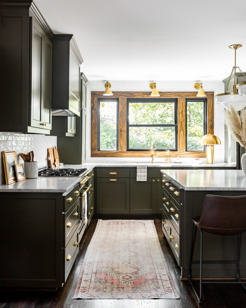 This is an example of a large traditional l-shaped eat-in kitchen in Dallas with a farmhouse sink, green cabinets, marble benchtops, white splashback, ceramic splashback, black appliances, with island, brown floor and white benchtop.