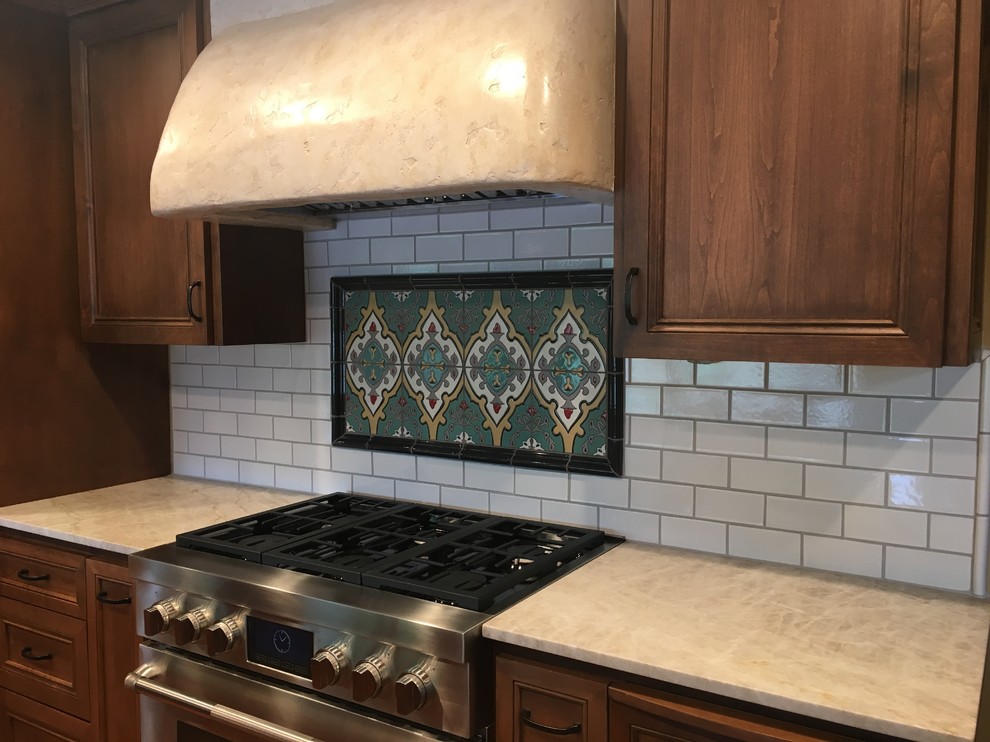 Inspiration for a mid-sized mediterranean single-wall eat-in kitchen in Sacramento with medium wood cabinets, white splashback, ceramic splashback, stainless steel appliances, quartz benchtops, beaded inset cabinets, no island, terra-cotta floors, beige floor and an undermount sink.