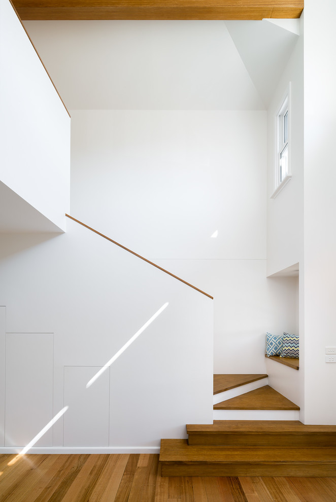 Photo of a modern wood staircase in Melbourne with painted wood risers and wood railing.