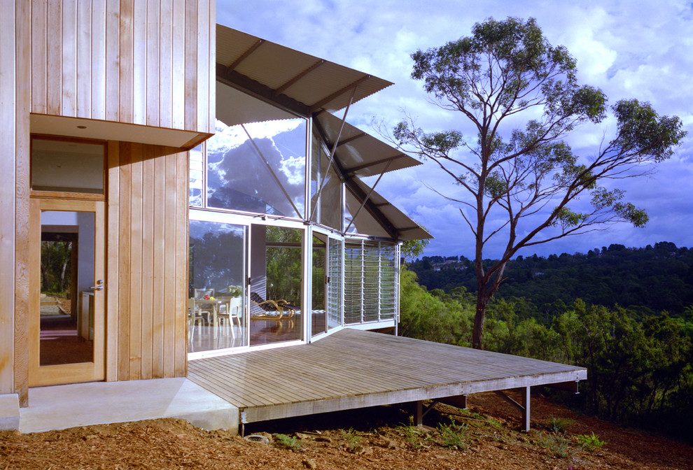 Inspiration for a mid-sized contemporary two-storey grey house exterior in Sydney with wood siding, a shed roof and a metal roof.