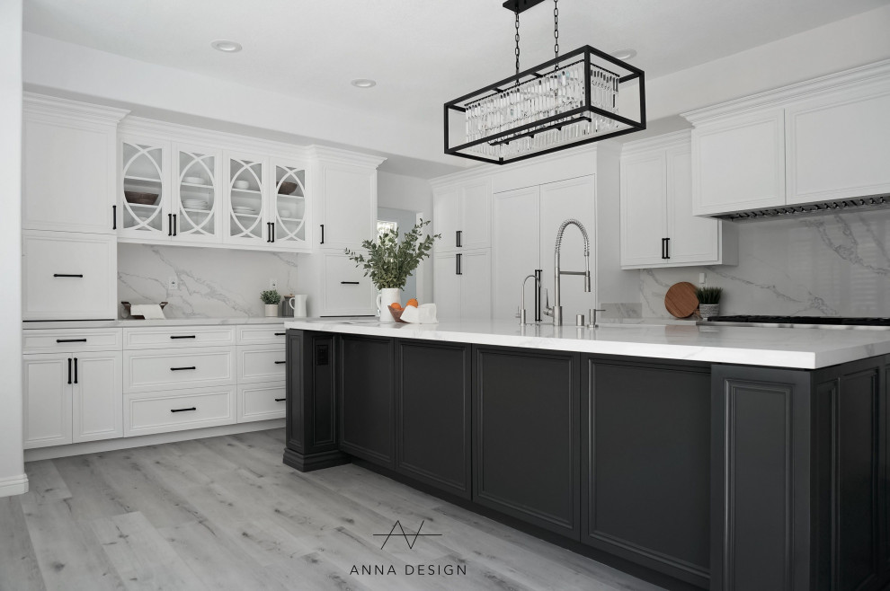 Large transitional l-shaped open plan kitchen in Los Angeles with a drop-in sink, louvered cabinets, white cabinets, quartzite benchtops, white splashback, engineered quartz splashback, stainless steel appliances, light hardwood floors, with island, grey floor and white benchtop.