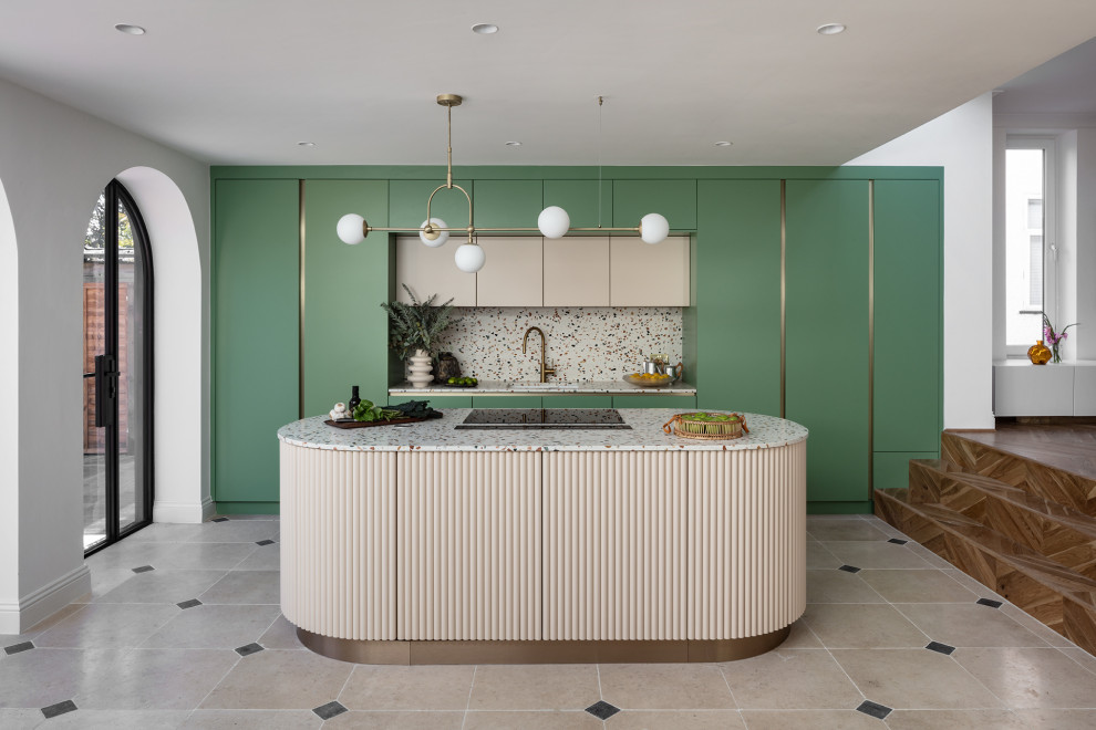 Contemporary galley kitchen in London with an undermount sink, flat-panel cabinets, green cabinets, terrazzo benchtops, panelled appliances, with island, beige floor and multi-coloured benchtop.