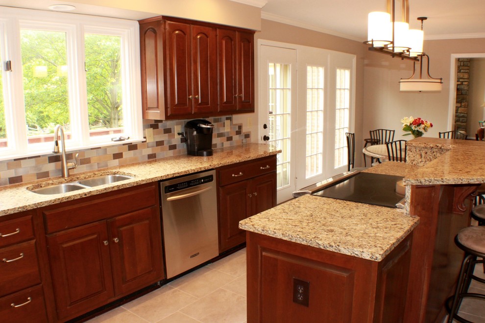 Eat-in kitchen - mid-sized transitional l-shaped porcelain tile and gray floor eat-in kitchen idea in Cincinnati with an undermount sink, raised-panel cabinets, medium tone wood cabinets, granite countertops, multicolored backsplash, ceramic backsplash, stainless steel appliances and an island