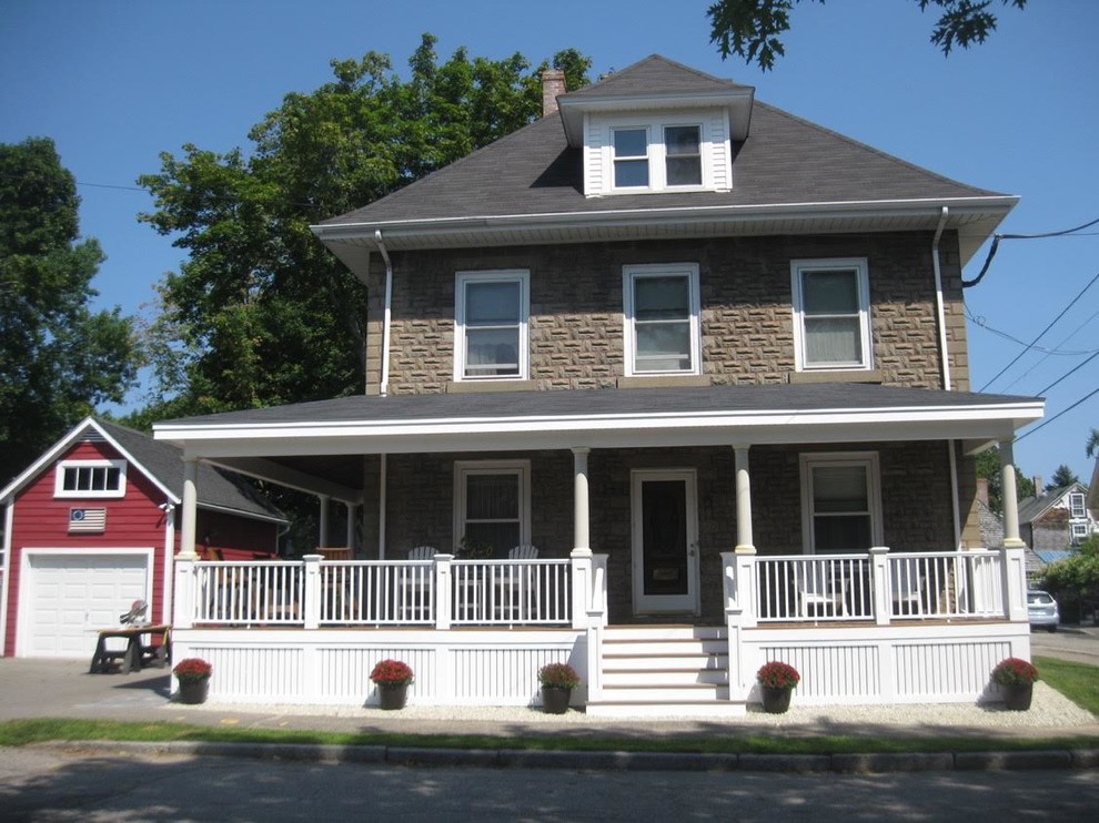 This is an example of a mid-sized traditional two-storey concrete brown house exterior in Boston with a hip roof and a shingle roof.